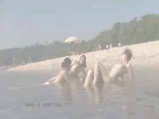 A public beach heats up with two splendid doll nudists
