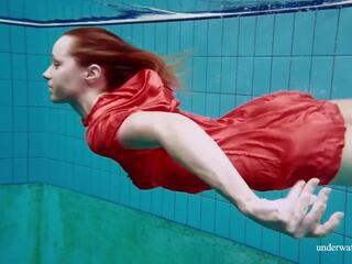 Rot lange kleid und groß titten floating im die schwimmbad